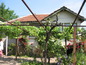 House for sale near Vidin. Cozy rural home with rose bushes & trellis vines in front